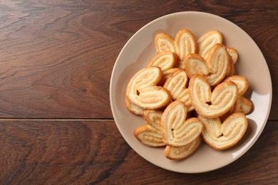 Photo of Delicious sweet palmier cookies on wooden table, top view