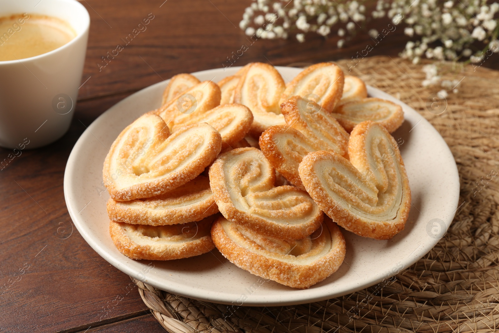 Photo of Delicious palmier cookies with coffee on wooden table