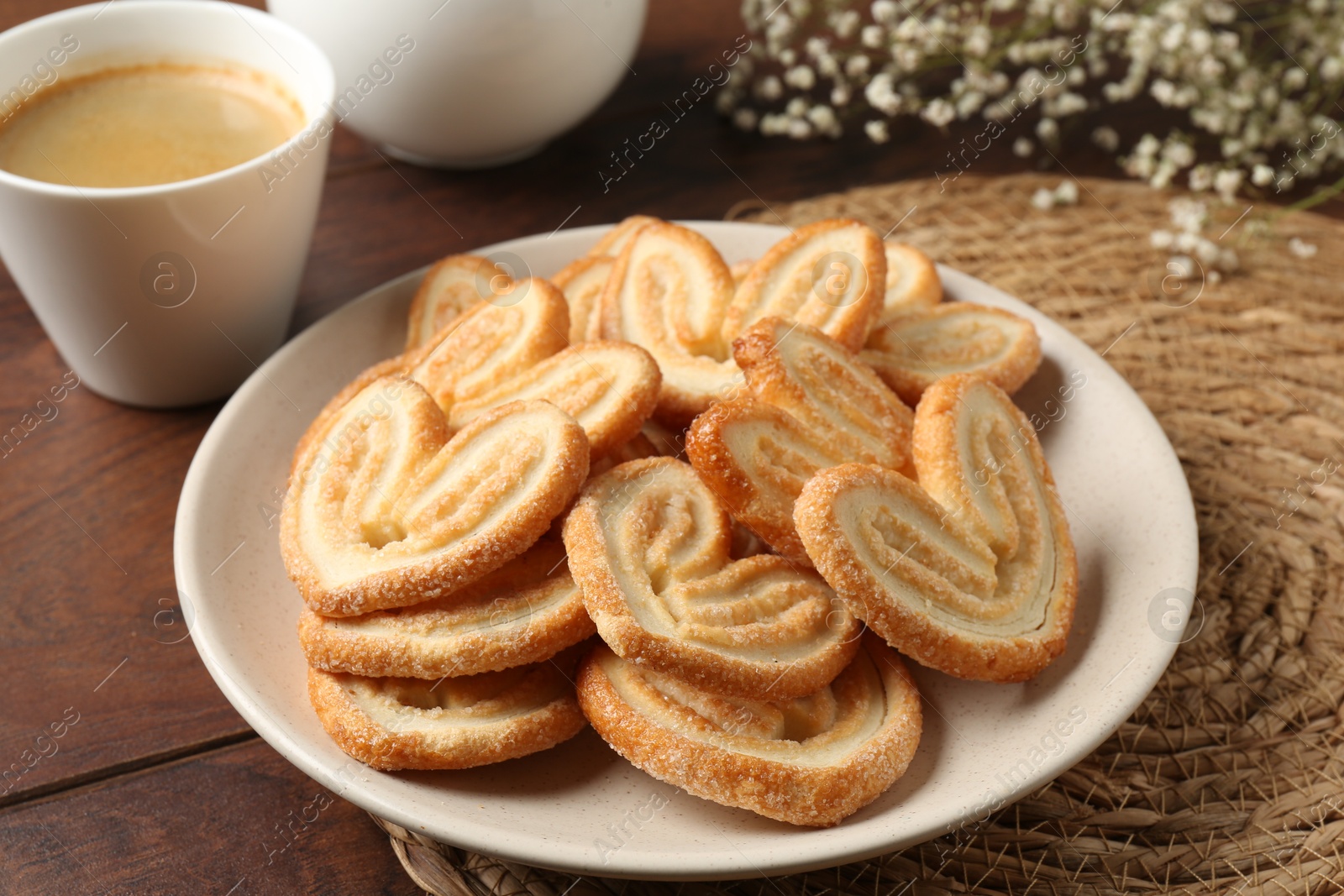 Photo of Delicious palmier cookies with coffee on wooden table