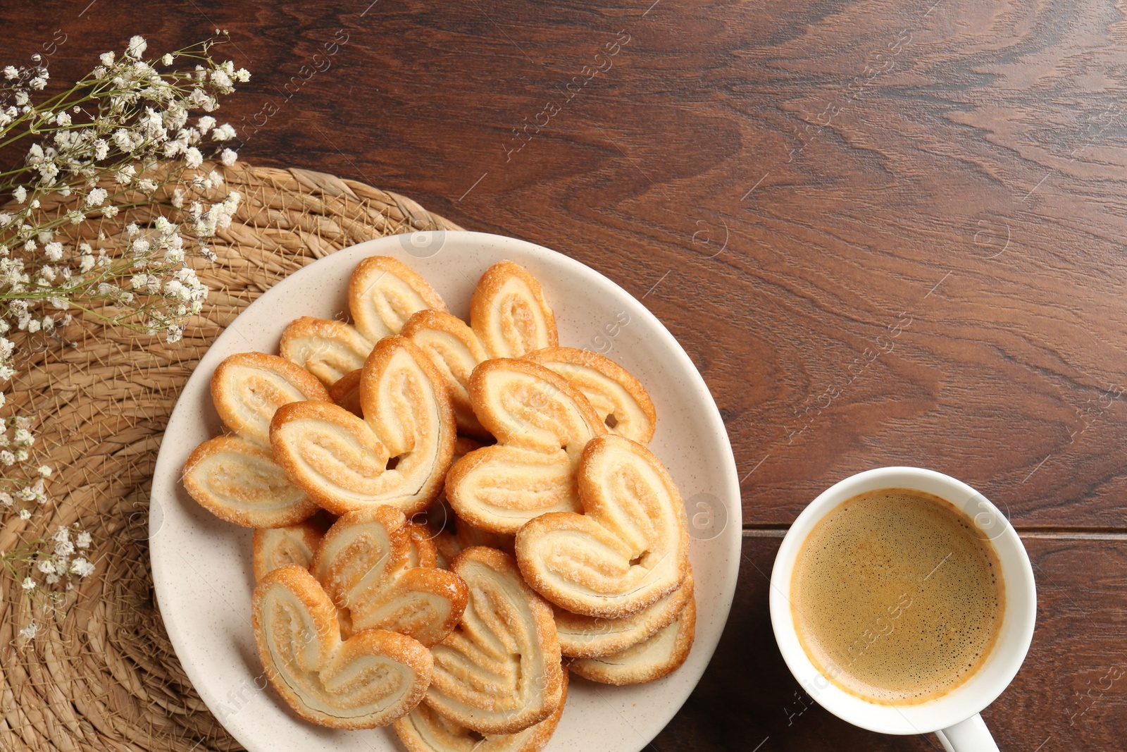 Photo of Delicious palmier cookies with coffee on wooden table, flat lay