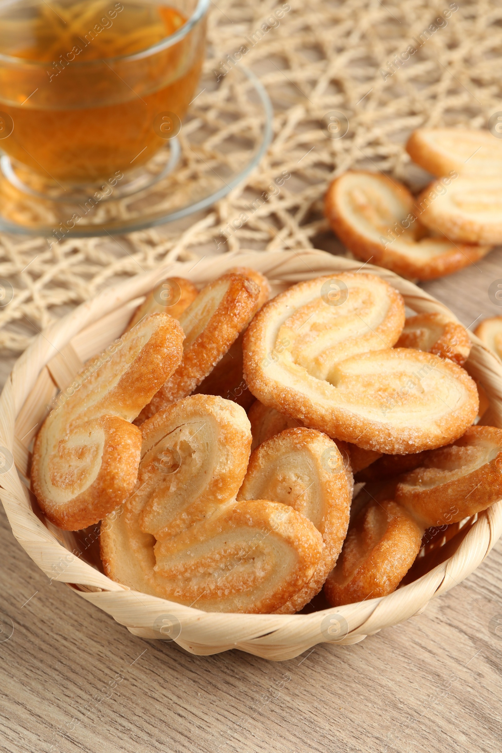 Photo of Delicious palmier cookies with tea on wooden table