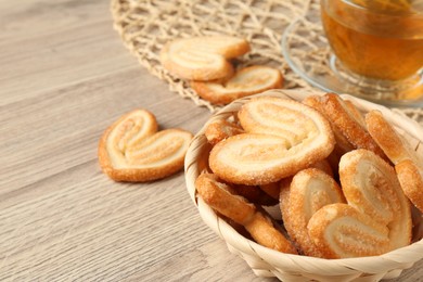 Photo of Delicious palmier cookies with tea on wooden table