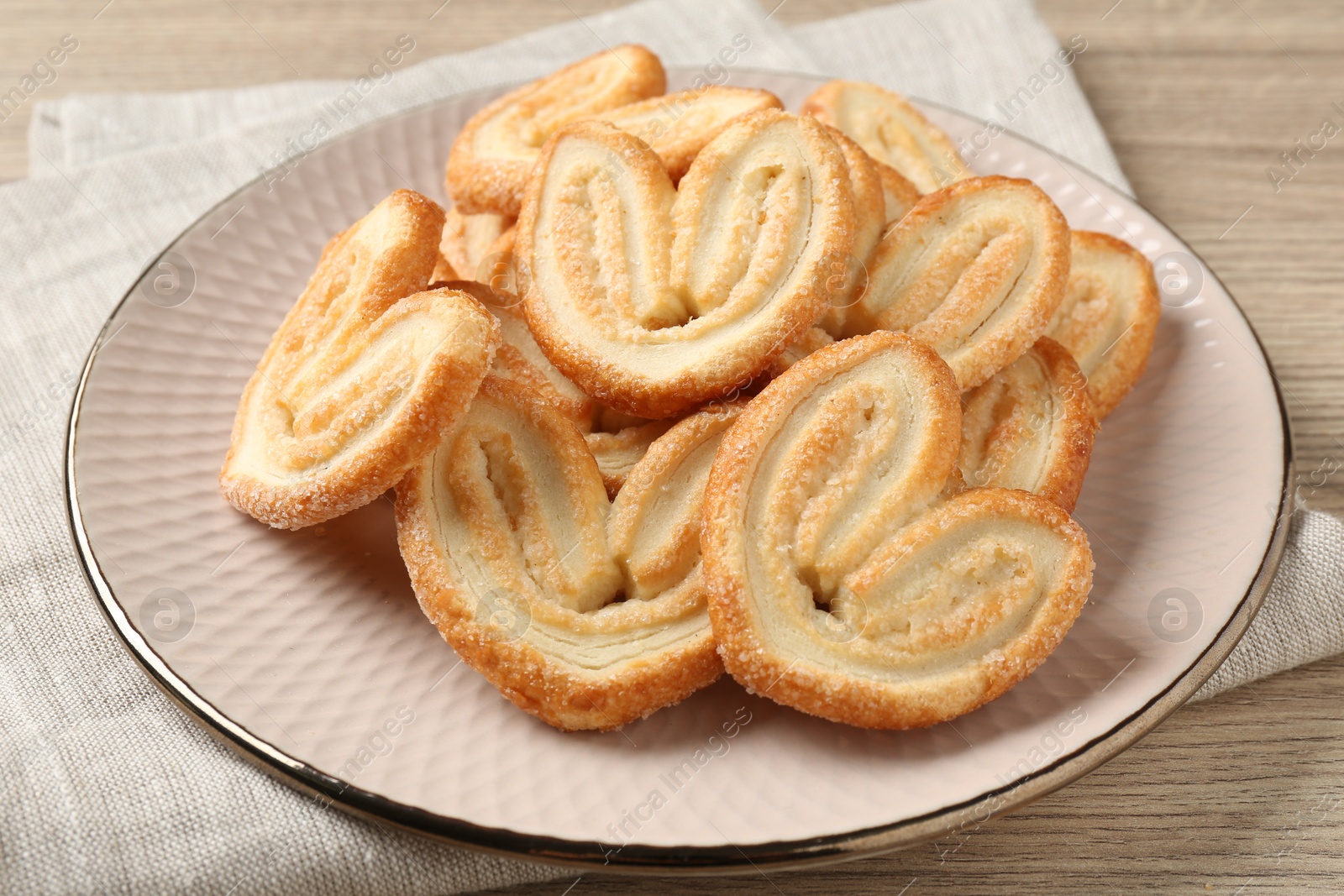 Photo of Delicious sweet palmier cookies on wooden table, closeup