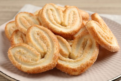 Photo of Delicious sweet palmier cookies on wooden table, closeup