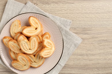 Photo of Delicious sweet palmier cookies on wooden table, top view