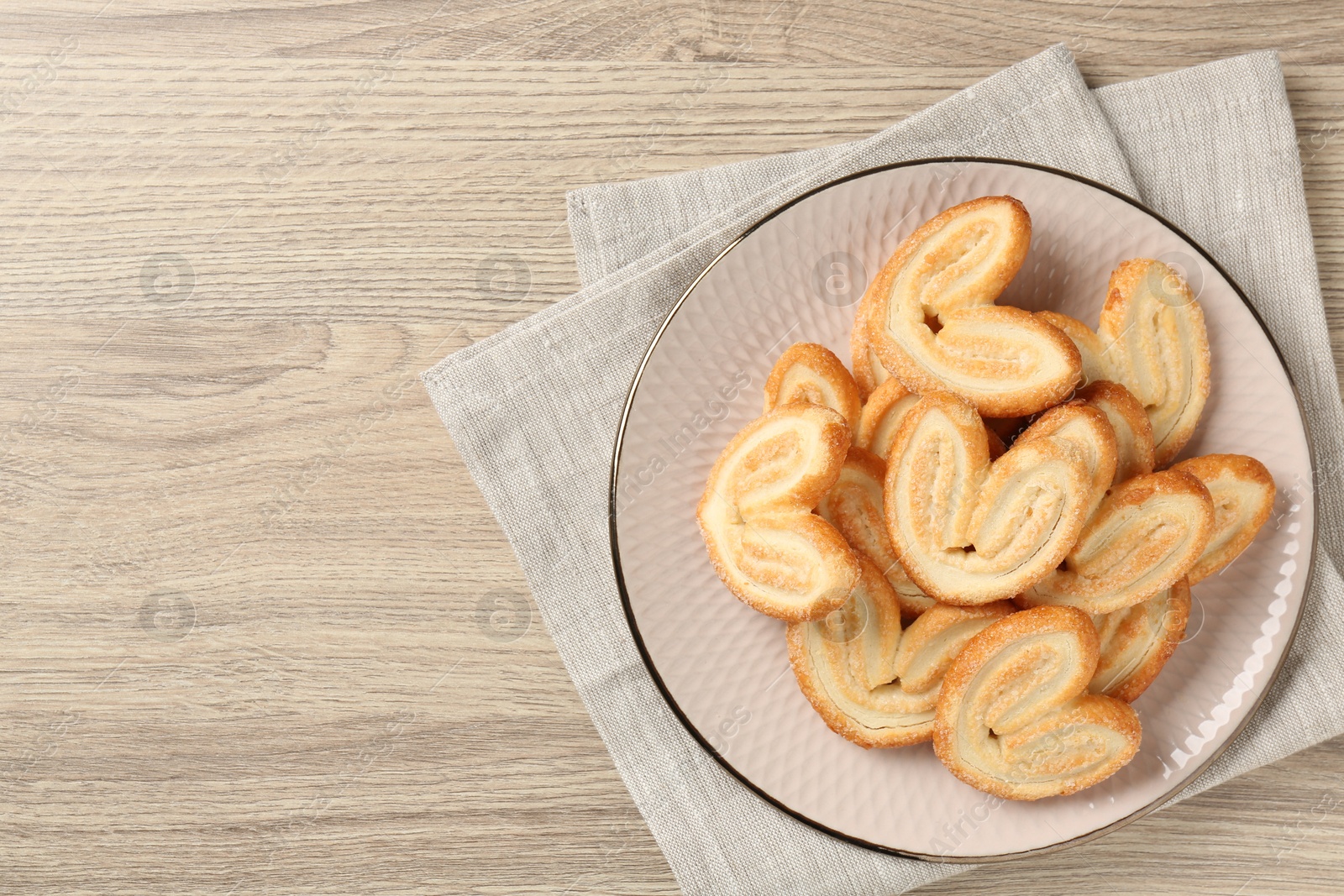 Photo of Delicious sweet palmier cookies on wooden table, top view