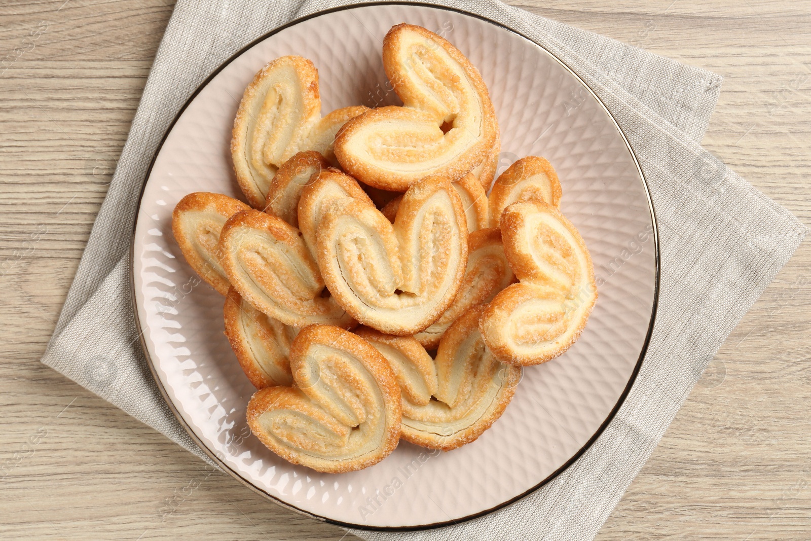 Photo of Delicious sweet palmier cookies on wooden table, top view