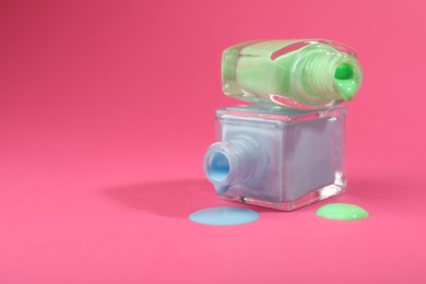 Photo of Bottles of nail polish on hot pink background. Space for text