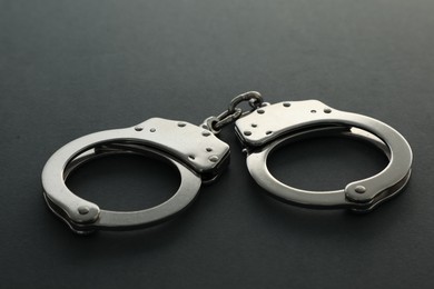 Photo of Classic chain handcuffs on black background, closeup