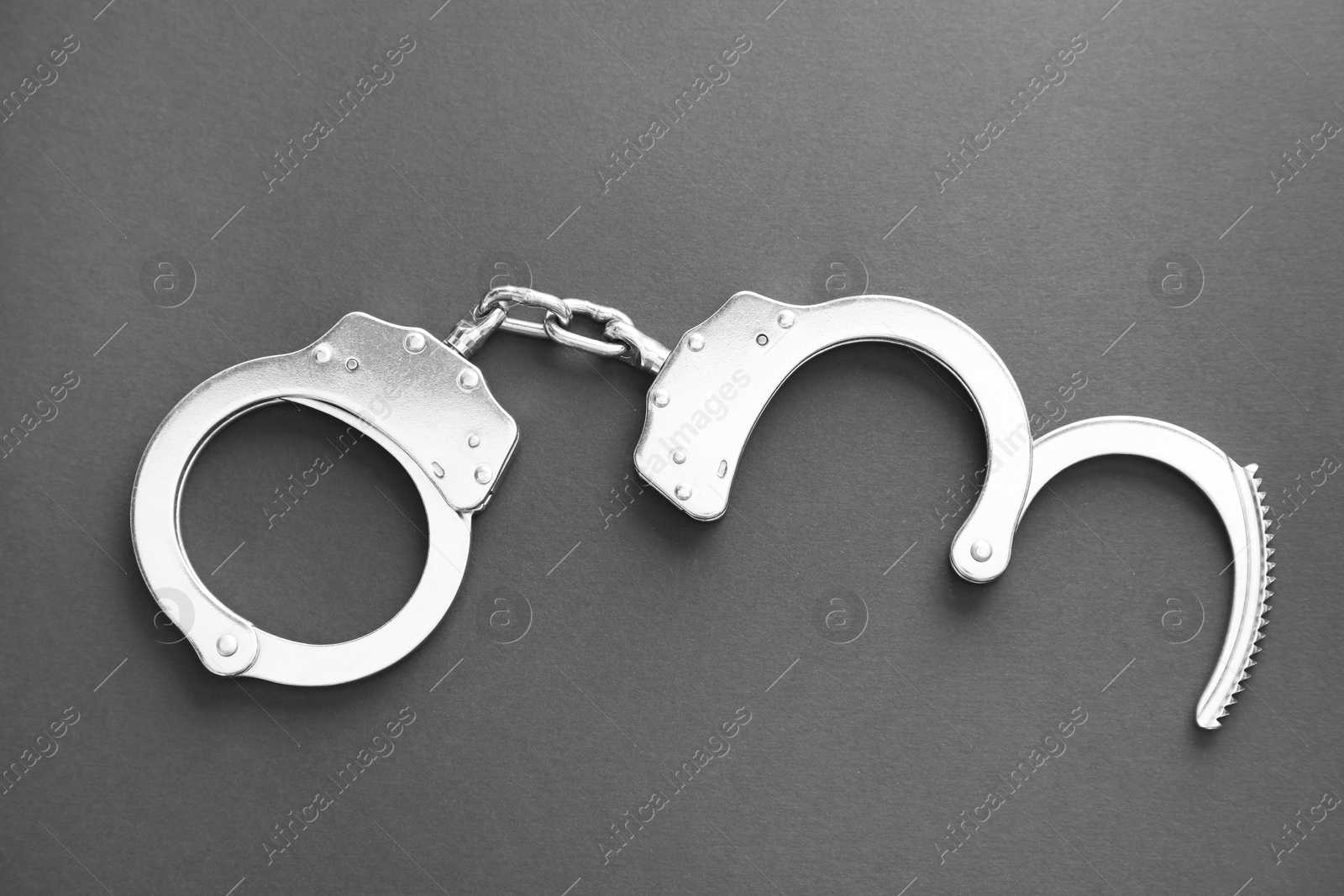 Photo of Classic chain handcuffs on black background, top view