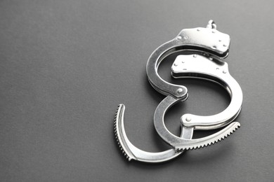 Photo of Classic chain handcuffs on black background, closeup. Space for text