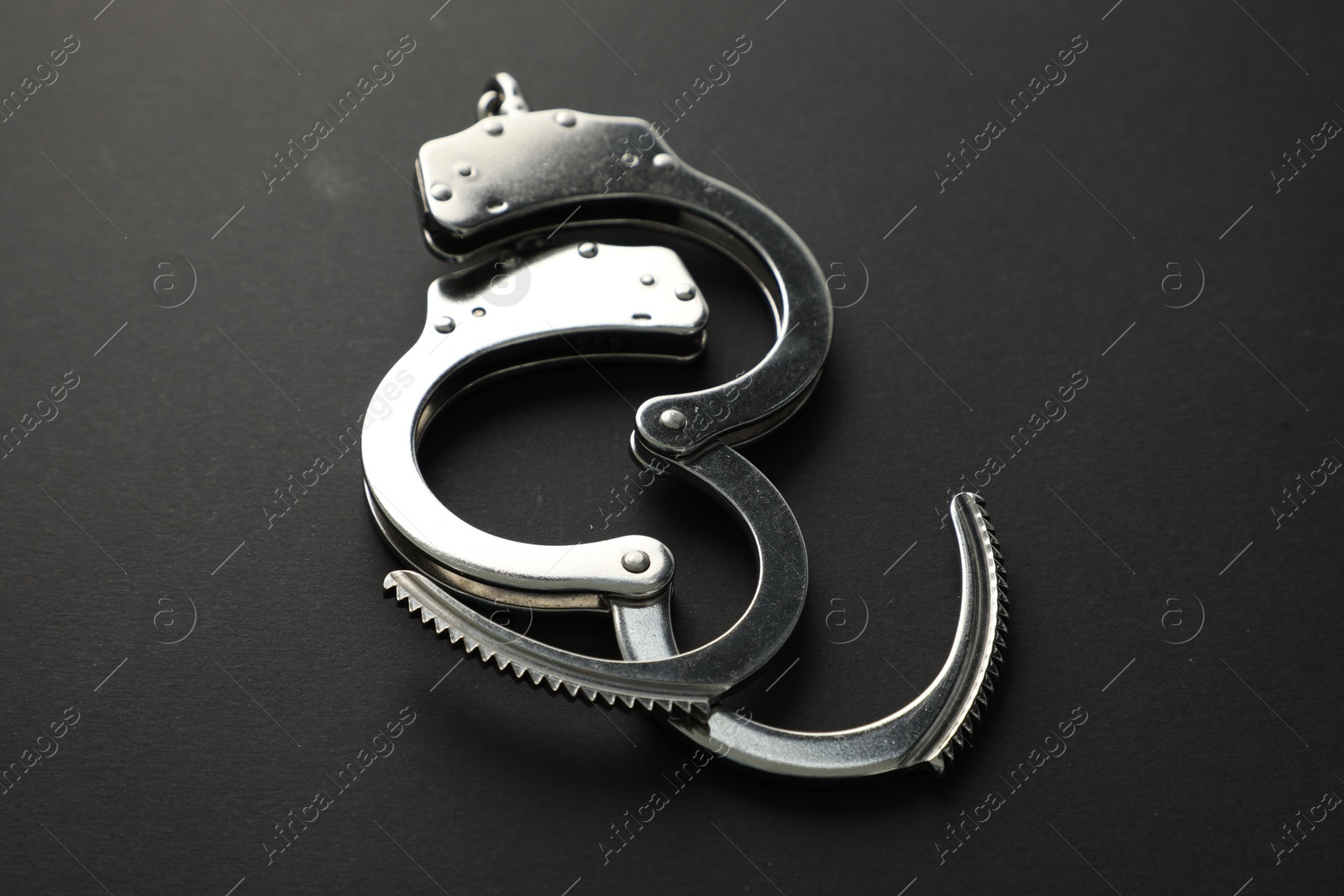 Photo of Classic chain handcuffs on black background, closeup