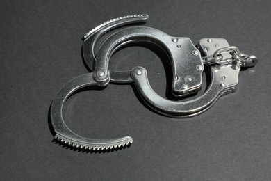 Photo of Classic chain handcuffs on black background, closeup