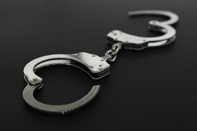 Photo of Classic chain handcuffs on black background, closeup