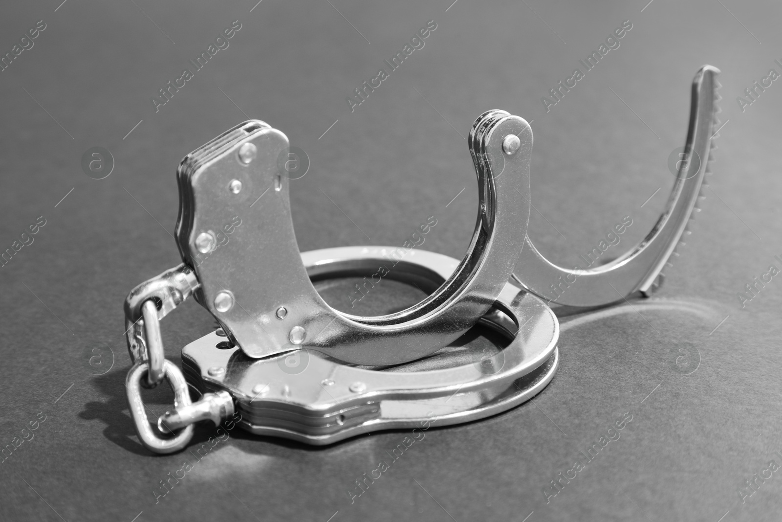 Photo of Classic chain handcuffs on grey background, closeup