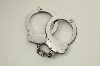 Photo of Classic chain handcuffs on white table, top view