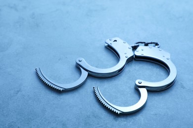 Photo of Classic chain handcuffs on table, closeup. Color toned