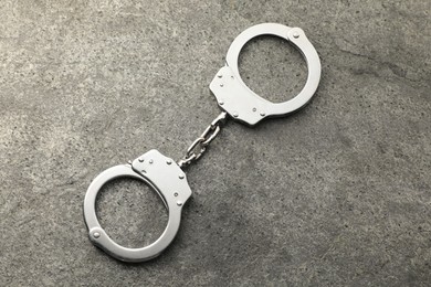 Photo of Classic chain handcuffs on grey table, top view