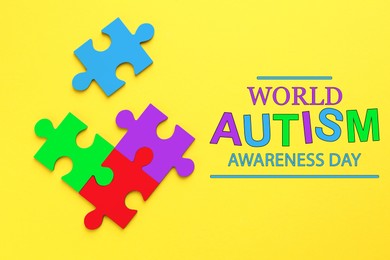 Image of World Autism Awareness Day text and colorful puzzle pieces on yellow background, top view