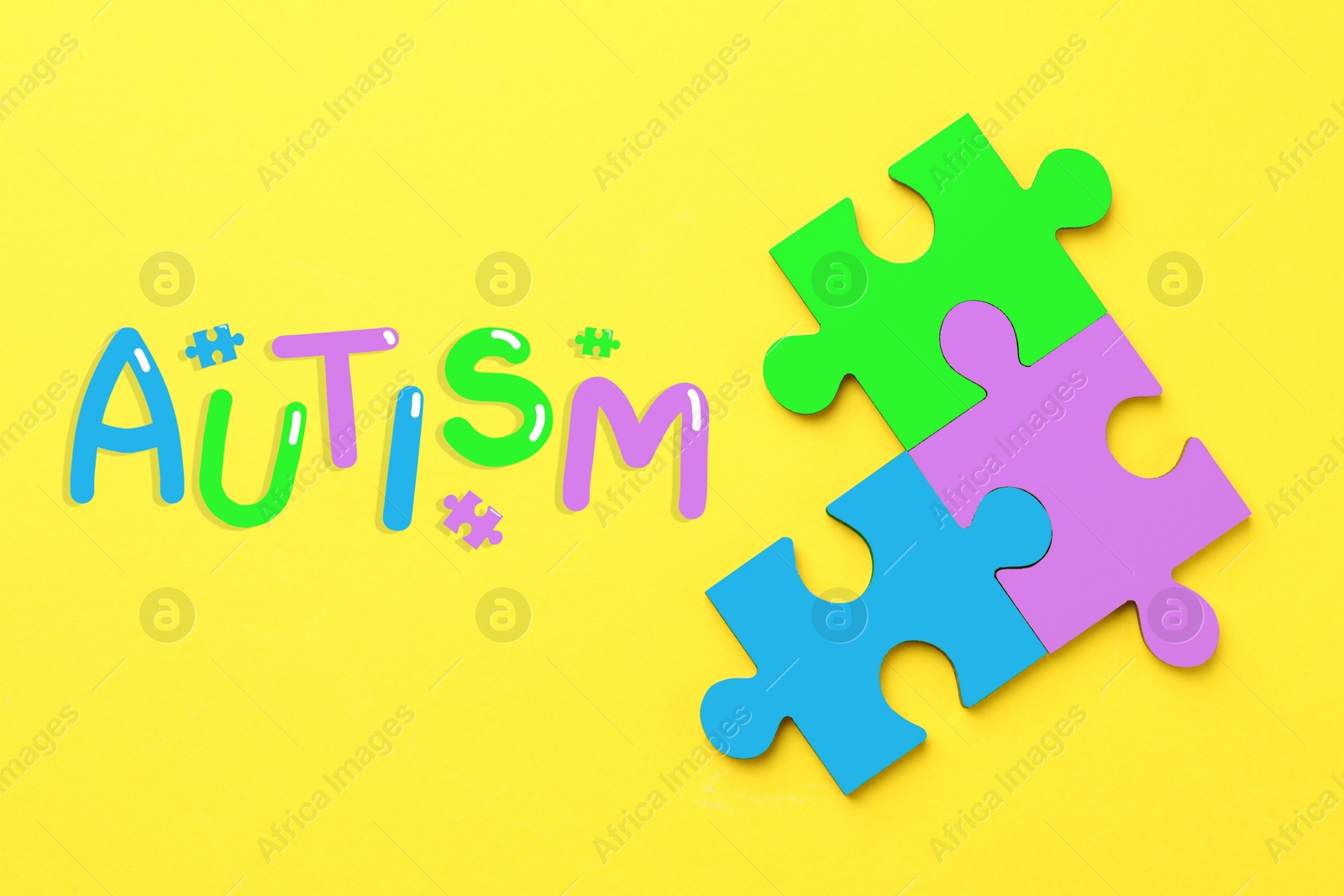 Image of Autism word and colorful puzzle pieces on yellow background, top view