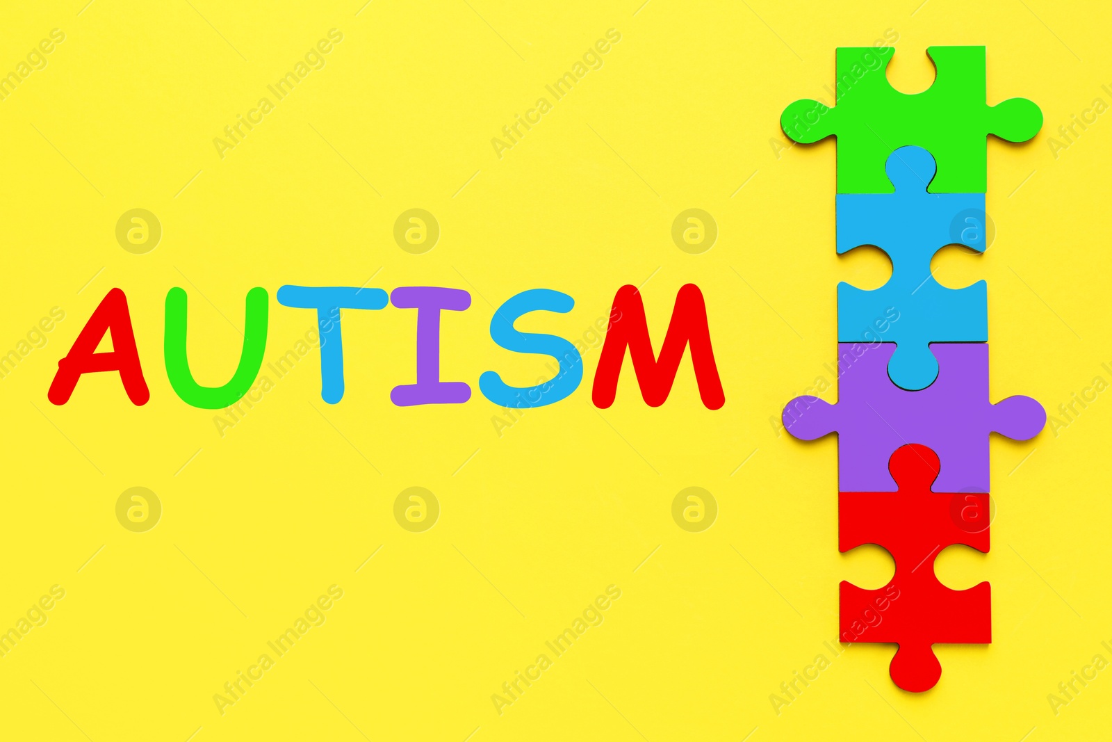 Image of Autism word and colorful puzzle pieces on yellow background, top view