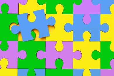 Image of Many colorful puzzle pieces as background. Symbol of autism