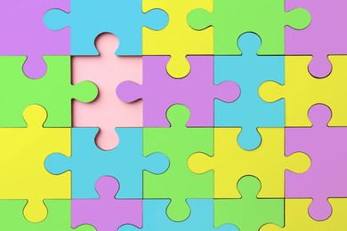 Image of Many colorful puzzle pieces on pink background, top view. Symbol of autism