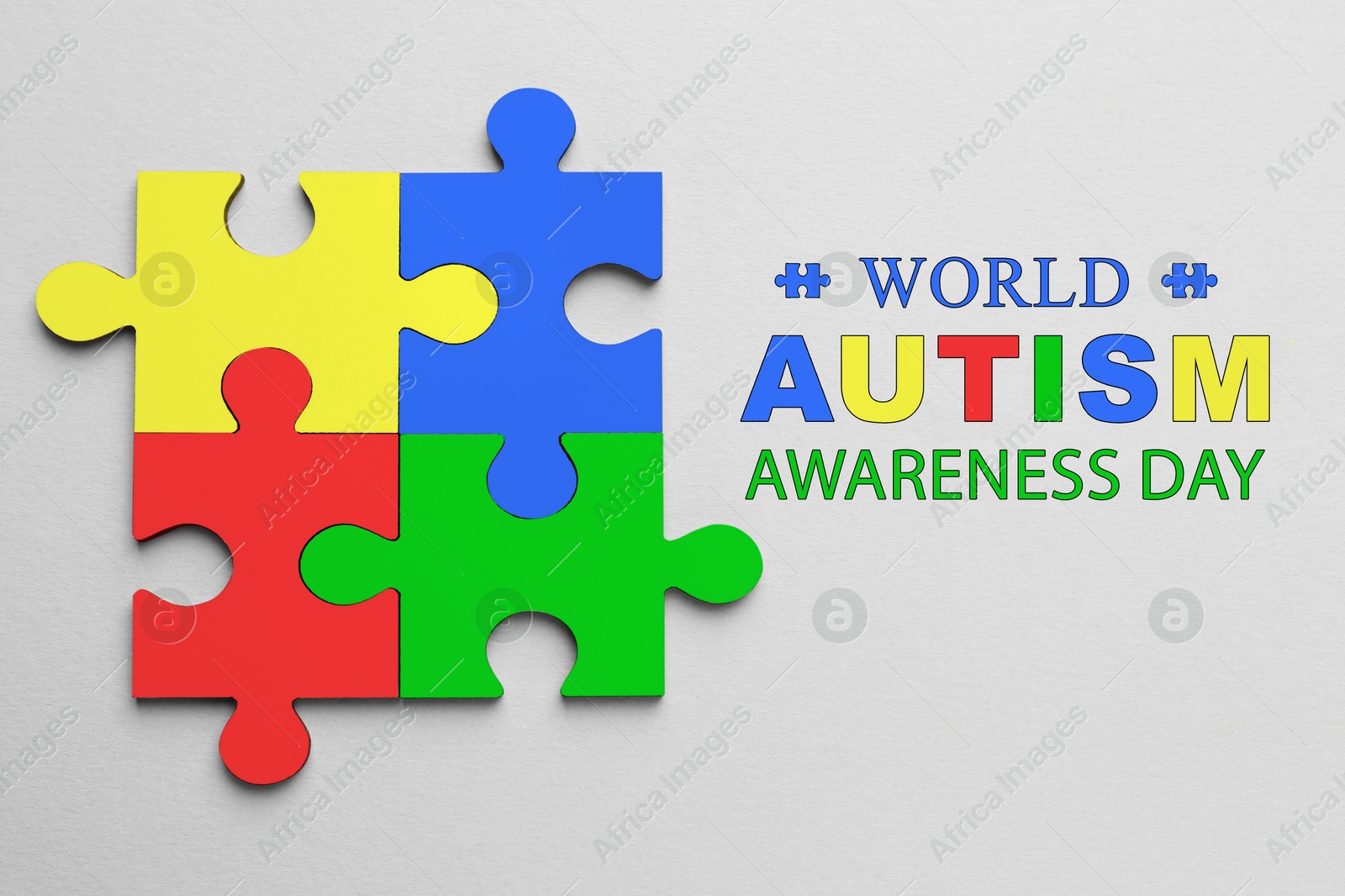 Image of World Autism Awareness Day text and colorful puzzle pieces on light grey background, top view