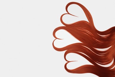 Photo of Red hair strands in shape of hearts on white background, top view. Space for text