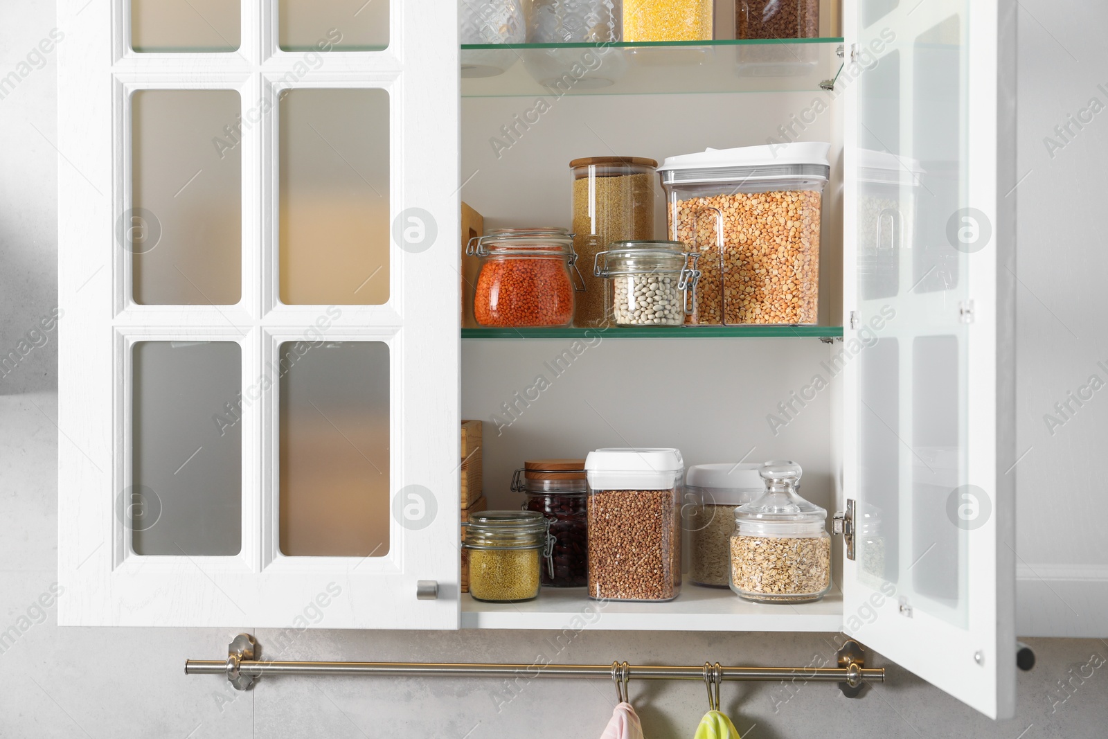 Photo of Different types of cereals and legumes in containers in kitchen