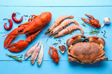 Different sea food on light blue wooden table, flat lay