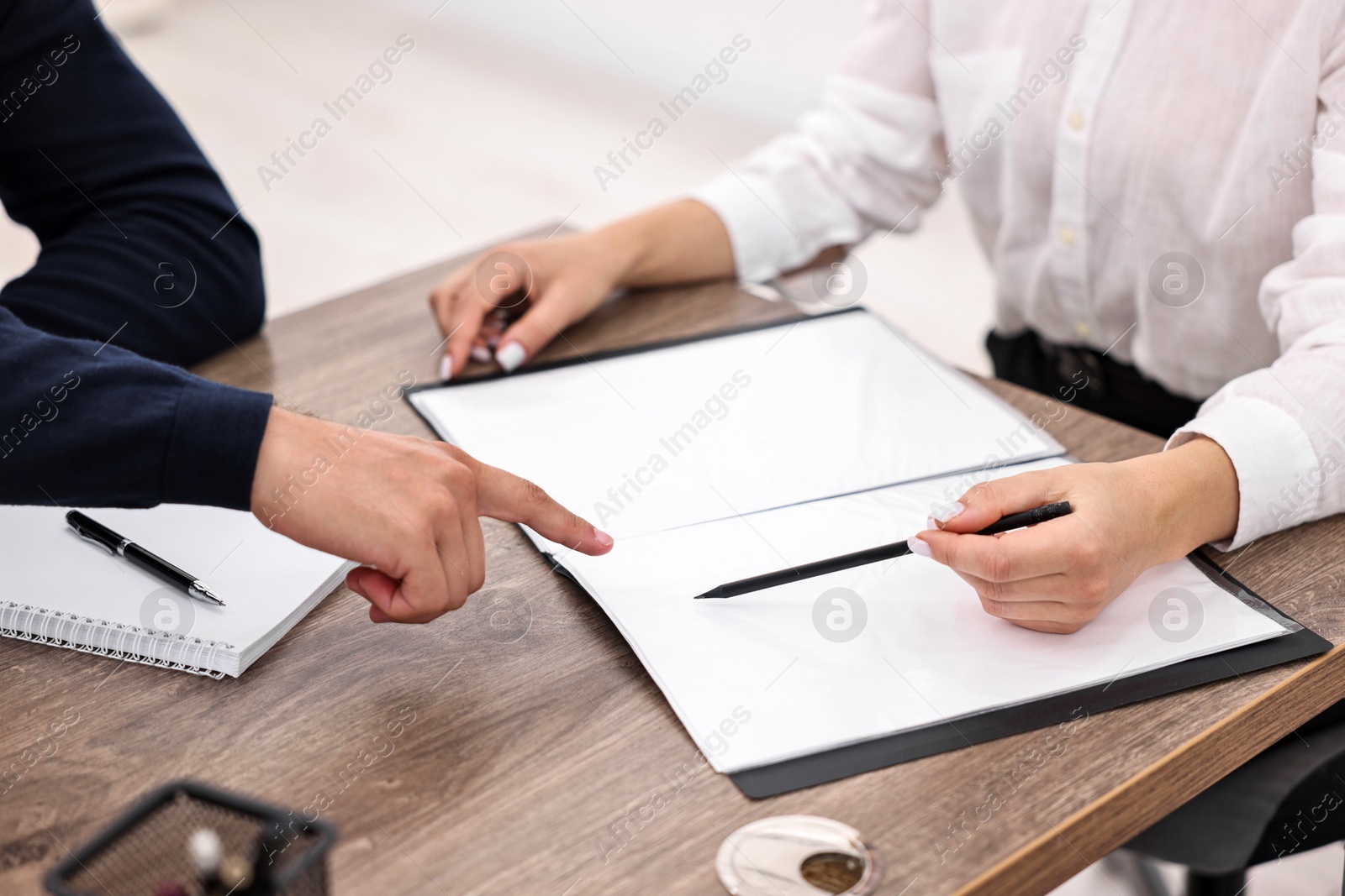 Photo of Banker working with client at wooden table in office, closeup