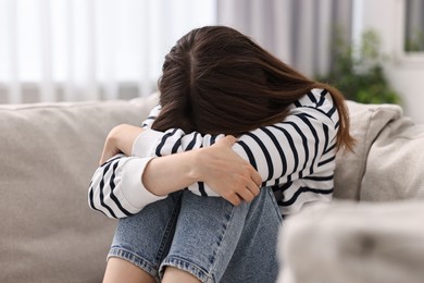 Photo of Loneliness concept. Sad teenage girl on sofa at home