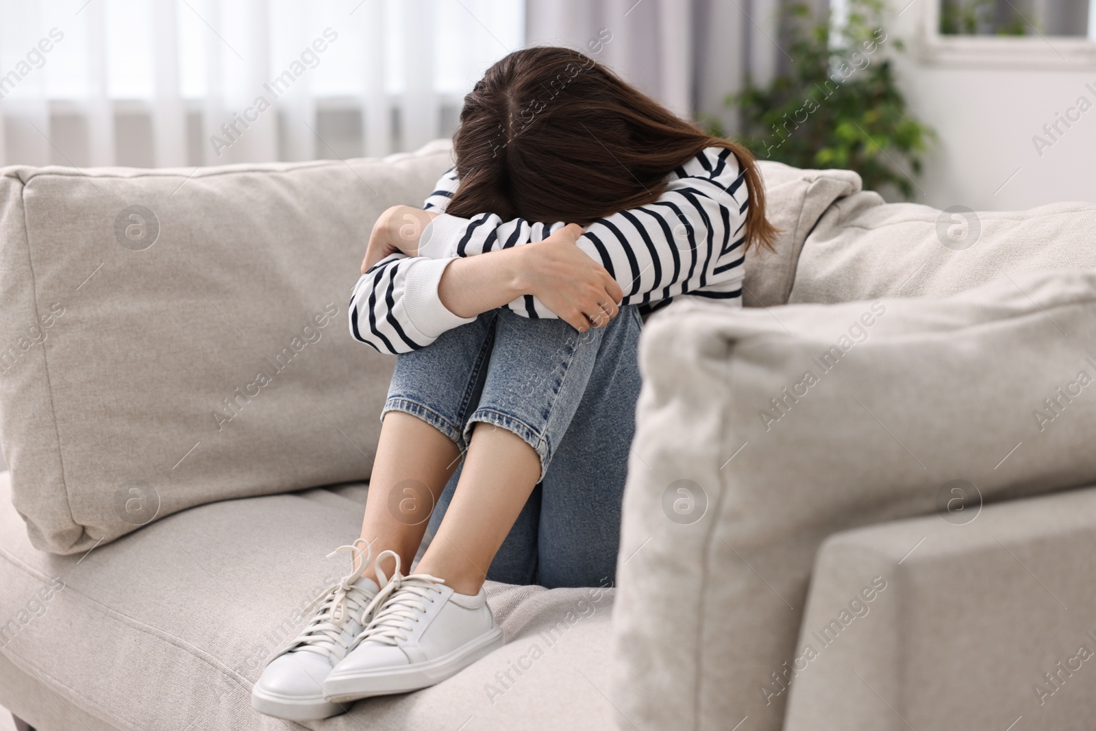 Photo of Loneliness concept. Sad teenage girl on sofa at home