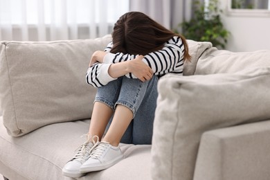 Loneliness concept. Sad teenage girl on sofa at home