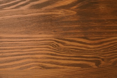 Photo of Applying walnut wood stain. Texture of wooden surface as background, top view