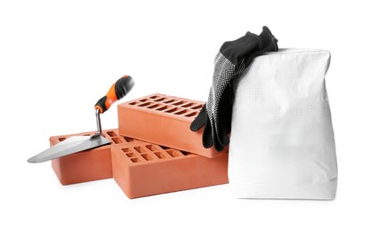 Red bricks, bag of cement, gloves and trowel on white background