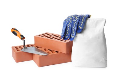 Photo of Red bricks, bag of cement, gloves and trowel on white background