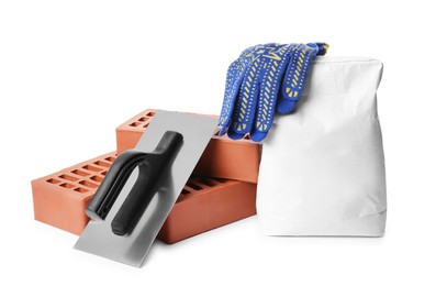 Photo of Red bricks, bag of cement, gloves and plastering trowel on white background