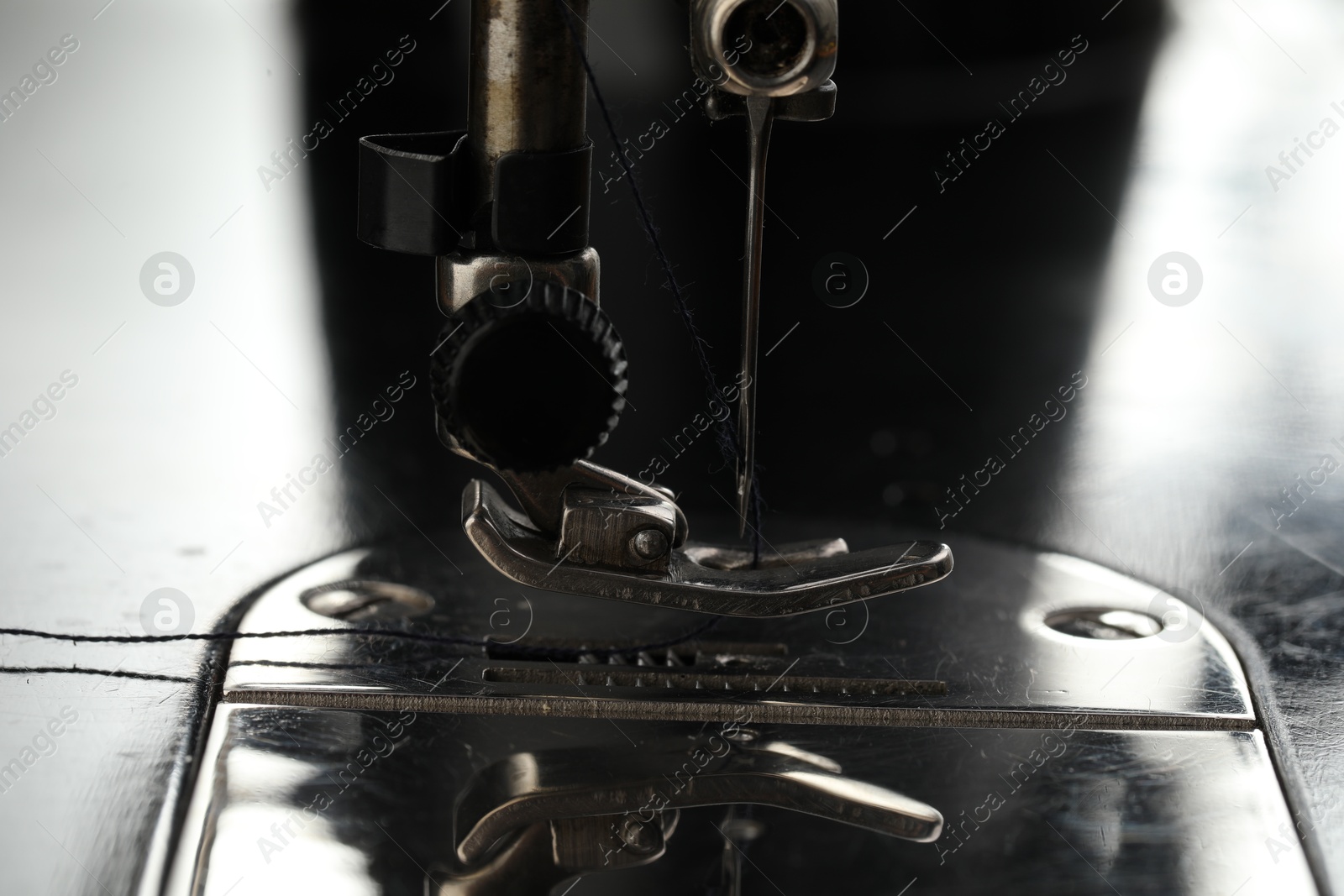 Photo of Professional sewing machine on blurred background, macro view