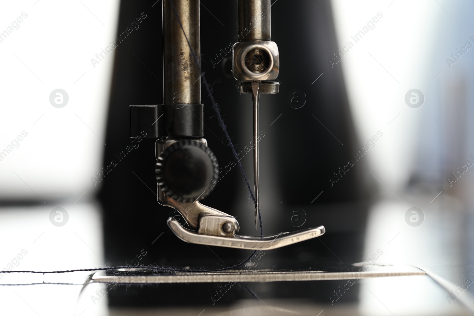 Photo of Professional sewing machine on blurred background, macro view