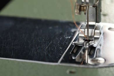 Photo of Professional sewing machine on blurred background, macro view