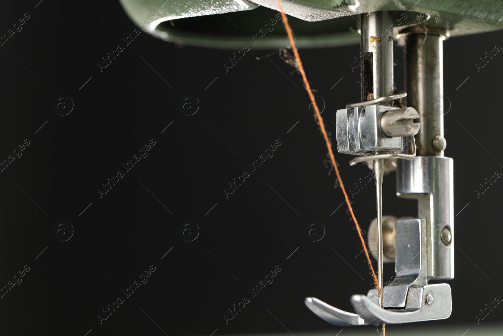 Photo of Professional sewing machine on black background, macro view. Space for text