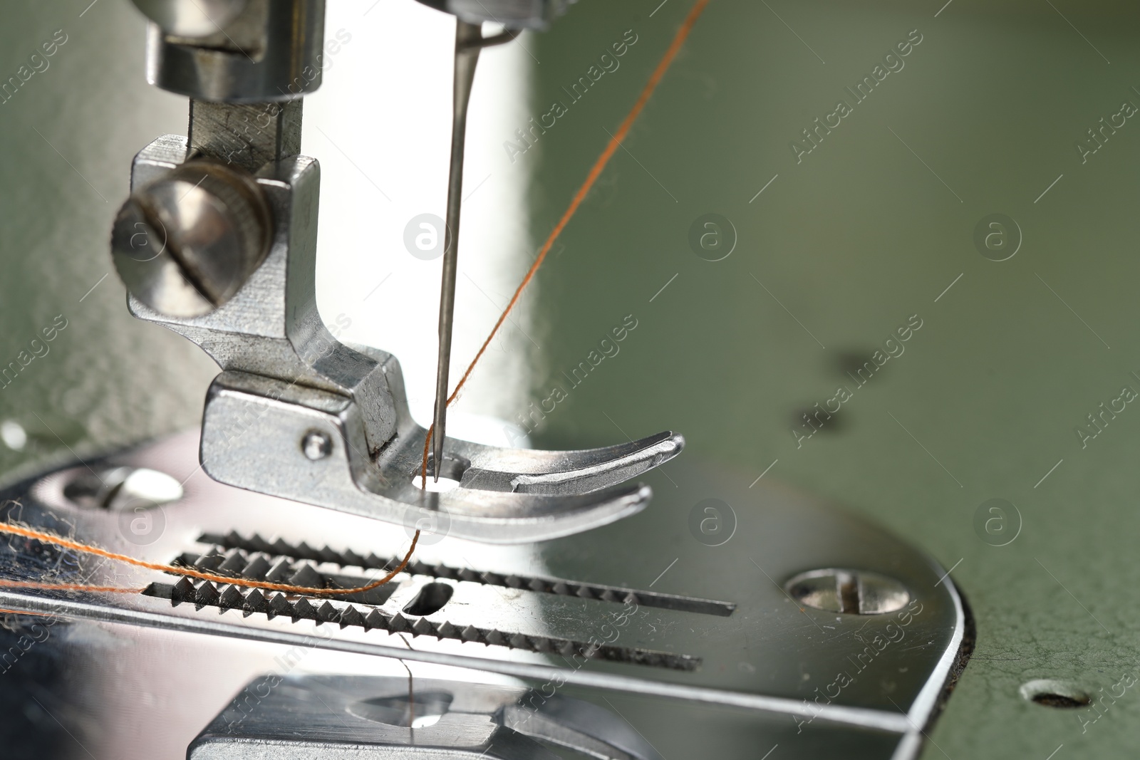 Photo of Professional sewing machine on blurred background, macro view