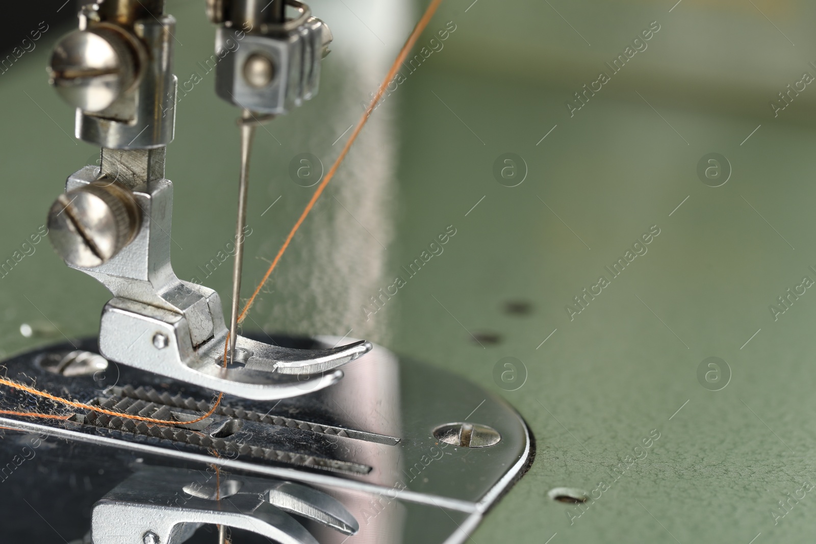 Photo of Professional sewing machine on blurred background, macro view