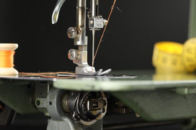 Photo of Professional sewing machine on blurred background, macro view