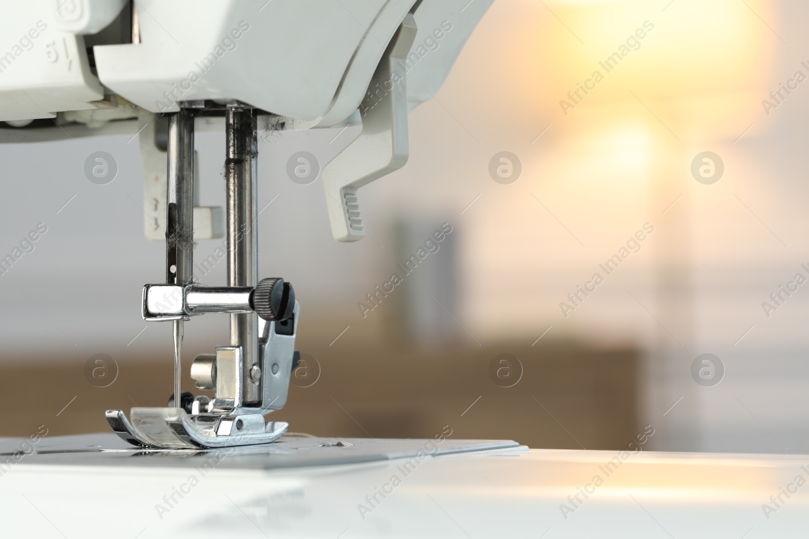 Photo of Sewing machine on blurred background, macro view. Space for text