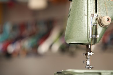 Photo of Vintage sewing machine with thread on blurred background, macro view. Space for text