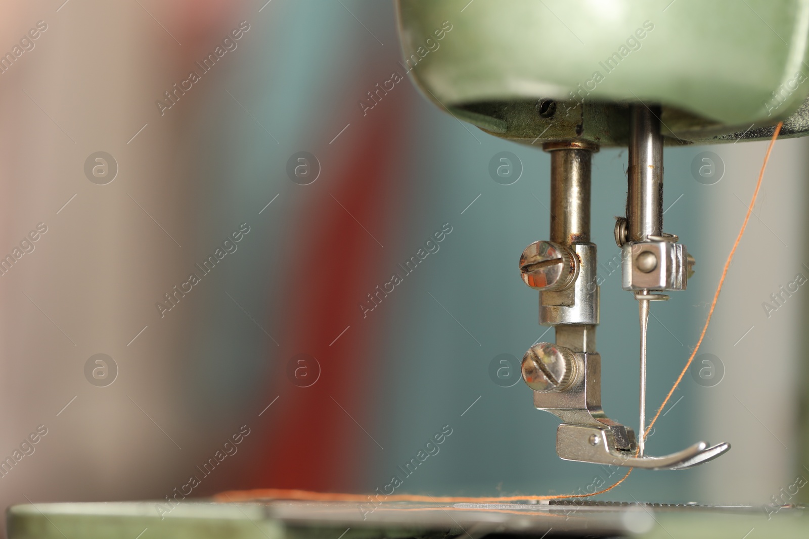 Photo of Vintage sewing machine with thread on blurred background, macro view. Space for text