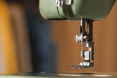 Photo of Vintage sewing machine with thread on blurred background, macro view. Space for text